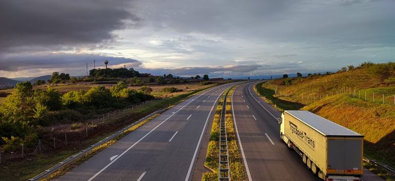 Open highway beneath dark clouds during changing weather
