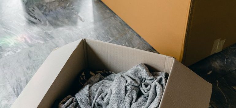Person carrying cardboard boxes into a new home