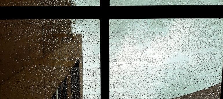 Raindrops covering a window during heavy rainfall